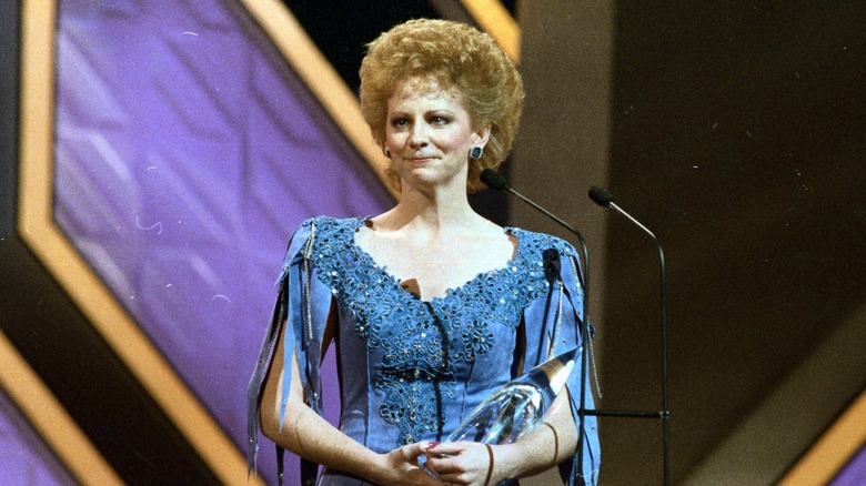 Reba McEntire wearing a blue dress at the Country Music Association awards in 1986.