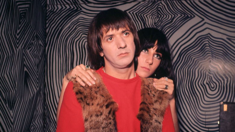 Cher standing behind Sonny Bono