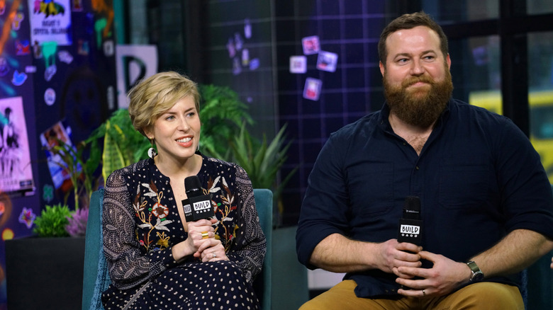 Erin and Ben Napier sit while holding microphones during and interview