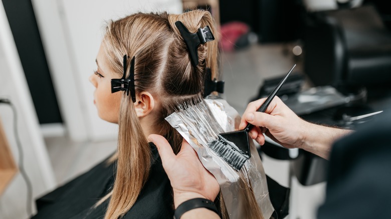 stylist bleaching a woman's hair