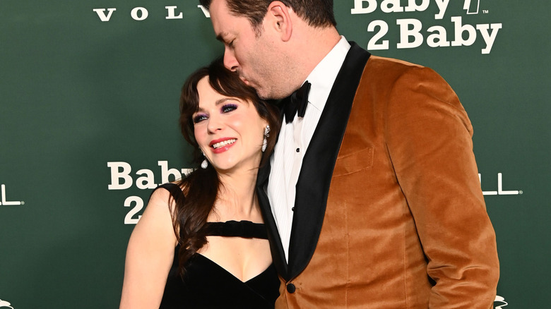 Jonathan Scott kissing Zooey Deschanel at a red carpet event.