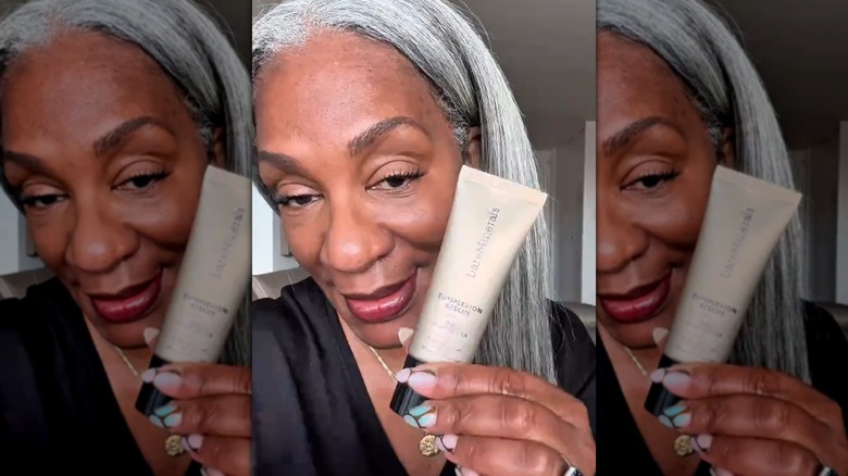Woman holding Bare Minerals Complexion Rescue tinted moisturizer