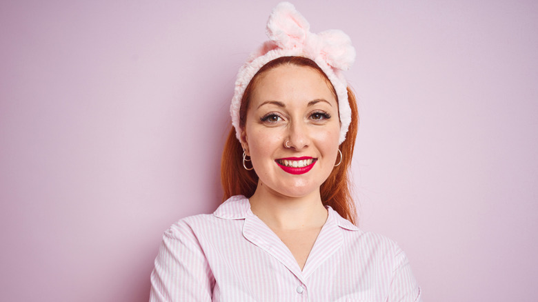 A woman with red hair wearing a pink headband