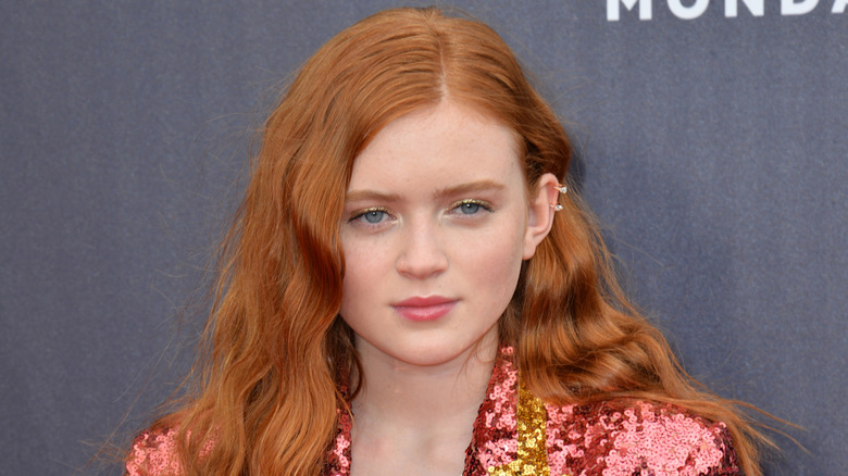 Sadie Sink posing in a pink jacket