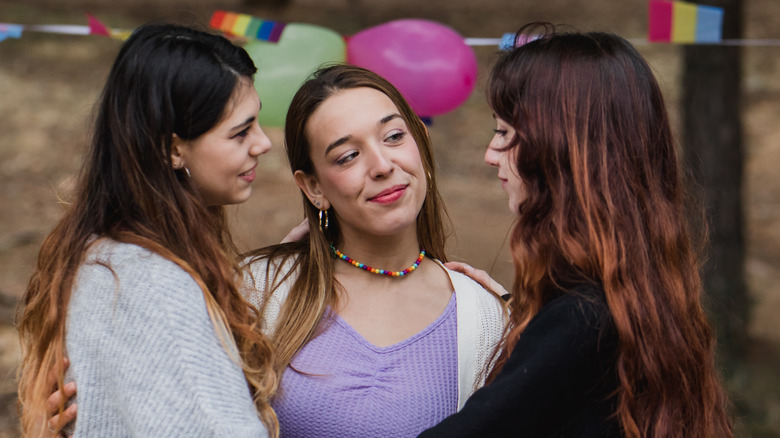 Three women romantically embracing