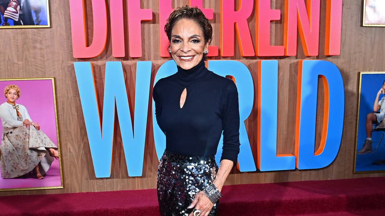 Jasmine Guy pictured wearing a black turtleneck top and sequin skirt