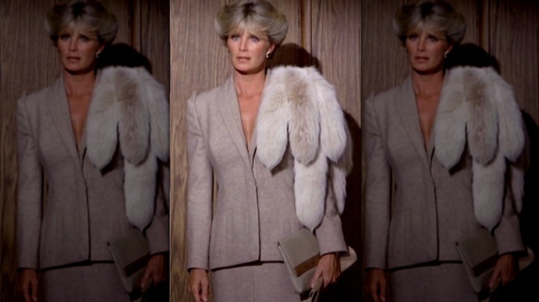 Linda Evans pictured as Krystle Carrington on Dynasty wearing a blazer, skirt, and fur shawl
