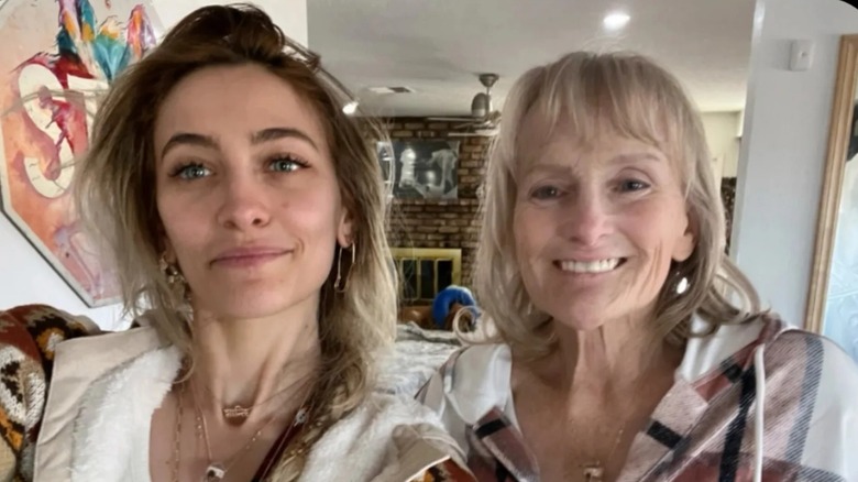 Debbie Rowe smiling while taking a photo with Paris Jackson.
