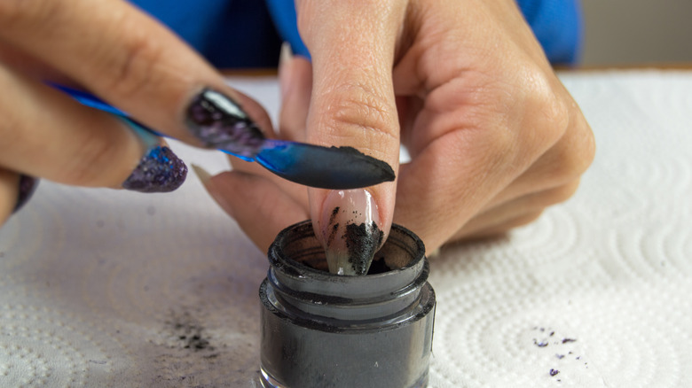 woman using dip powder on nails