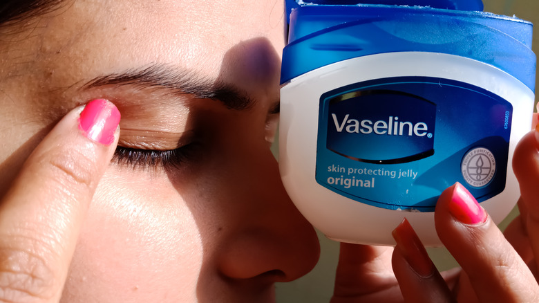 Person holding Vaseline bottle up to face