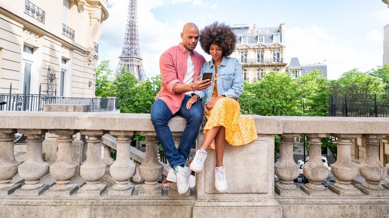 couple sitting on bridge 