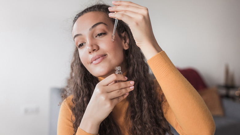 woman applying skincare serum