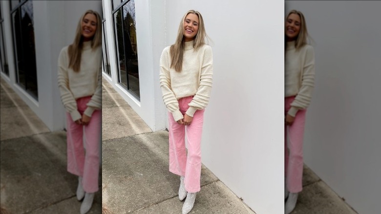 Pink jeans with a cream sweater