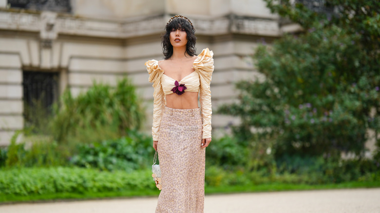 woman wearing skirt and top with rose