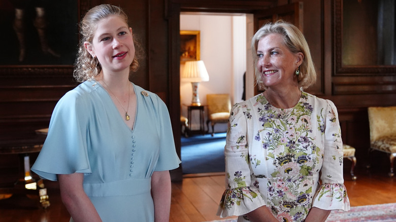 Lady Louise wears a curly lob and blue dress pictured with Duchess Sophie in a white floral dress