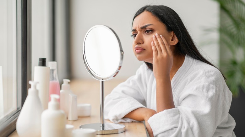 Woman examining dull skin