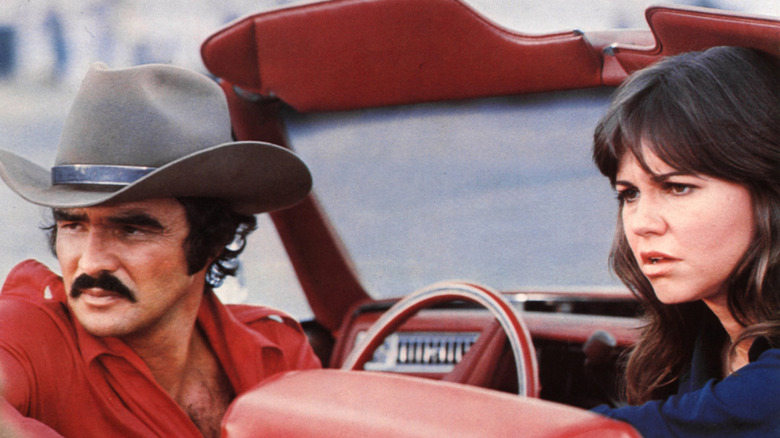 Burt Reynolds and Sally Field are picture sitting in a convertible on set of 'Smokey and the Bandit'