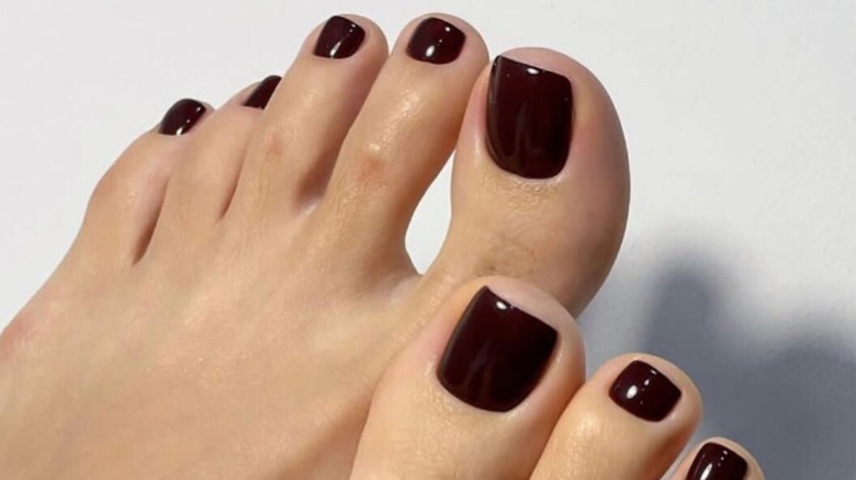 Pedicure with dark brown nail polish.