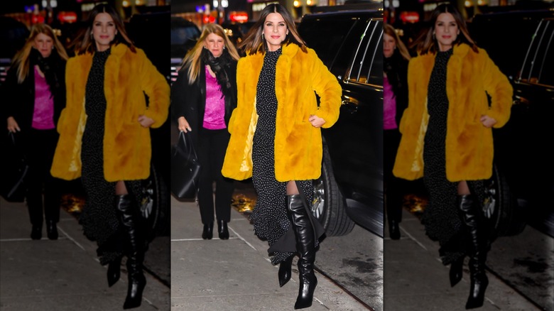 Sandra Bullock using a polka-dot dress and a statement fur jacket