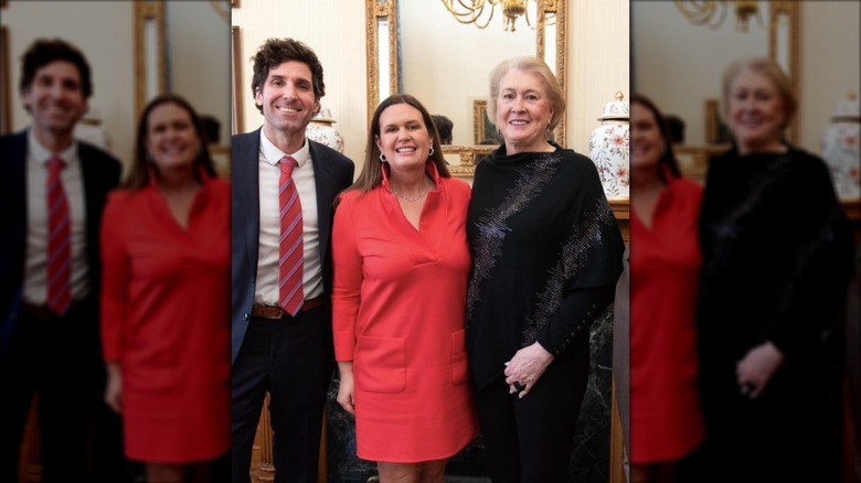 Sarah Huckabee Sanders in a red shift dress with her husband and mom
