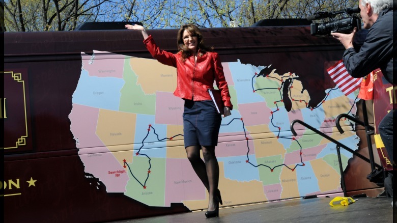 Sarah Palin waves from the stage in a leather jacket