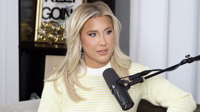 Savannah Chrisley talks into a microphone while hosting her podcast