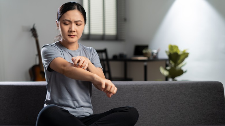 Woman scratching her elbow