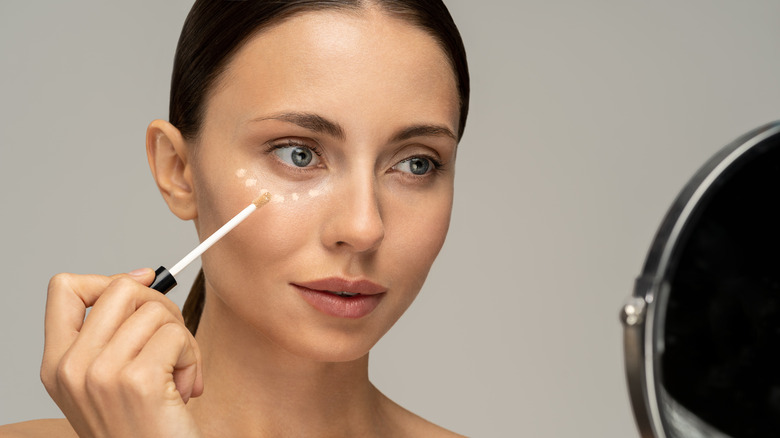 woman applying concealer