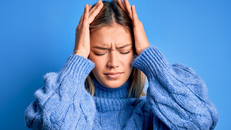 woman in pain grabbing head