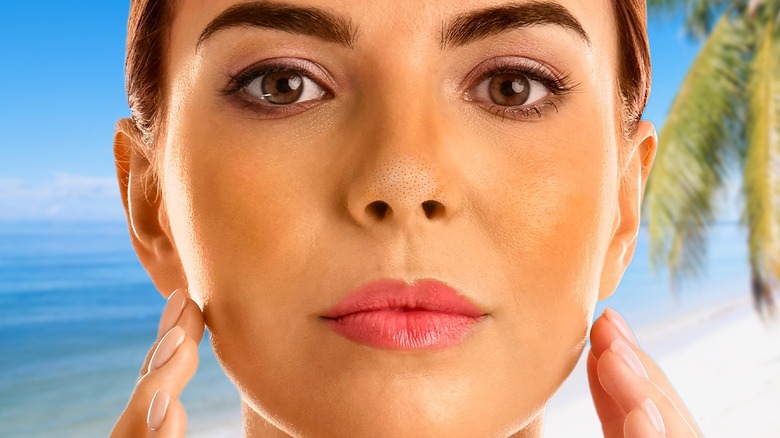 woman examining acne in mirror