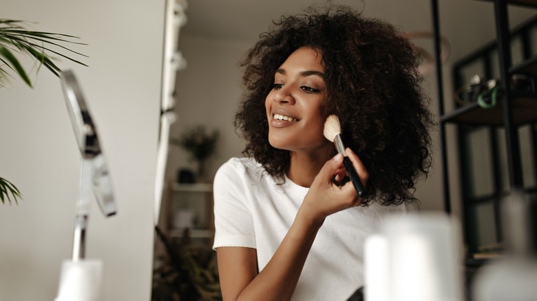 smiling woman applying makeup