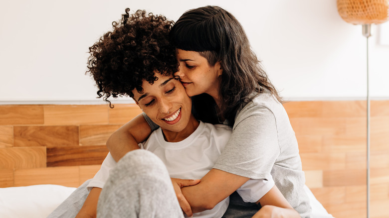 couple affectionately hugging in bed