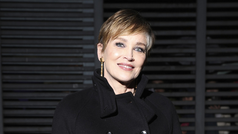 Sharon Stone wears a gray-streaked pixie cut and black peacoat during Milan Fashion 2024
