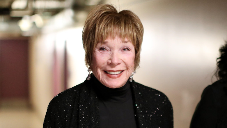 Shirley MacLaine smiles at a camera