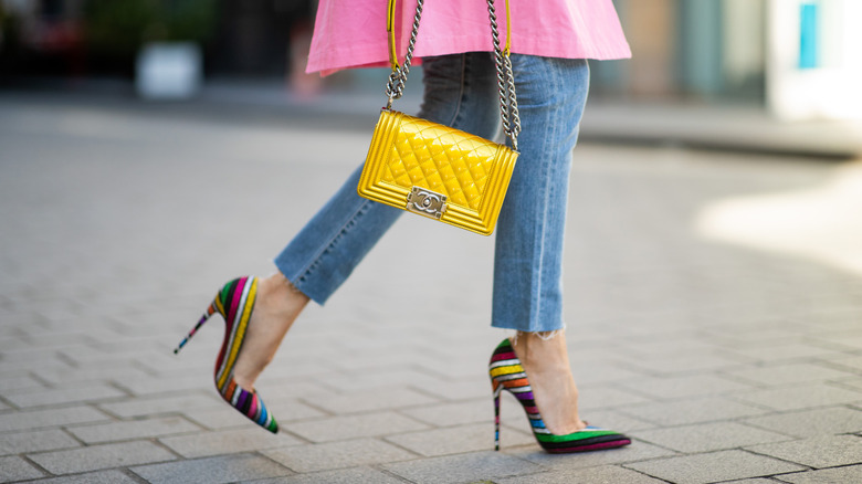 Close up of colorful stiletto heels being worn with skinny jeans