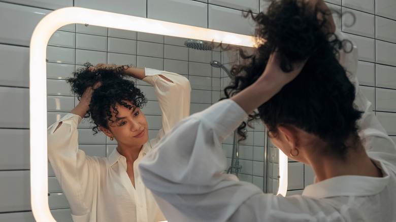 woman pulling hair in ponytail 