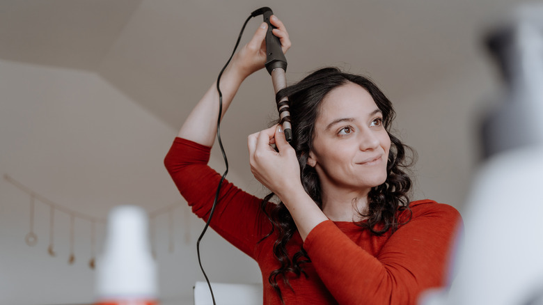 girl curling her hair 