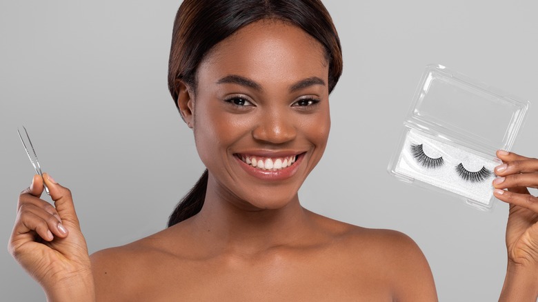 young black woman holding fake lashes