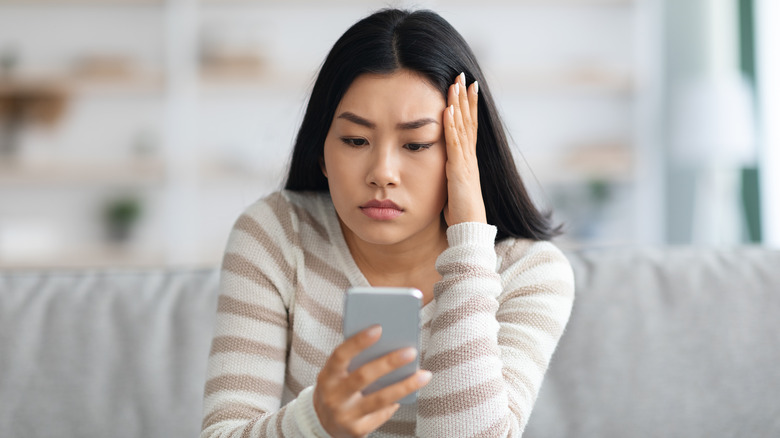 stressed woman looking at phone
