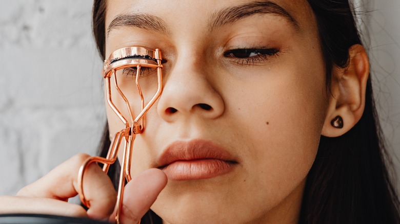 girl curling eyelashes