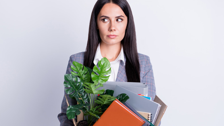 Businesswoman holding box of belongings