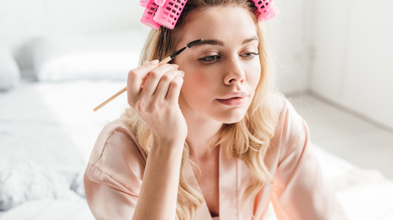 Woman brushing her eyebrows