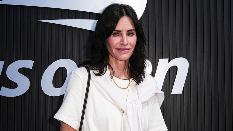 Courteney Cox posing in a white outfit