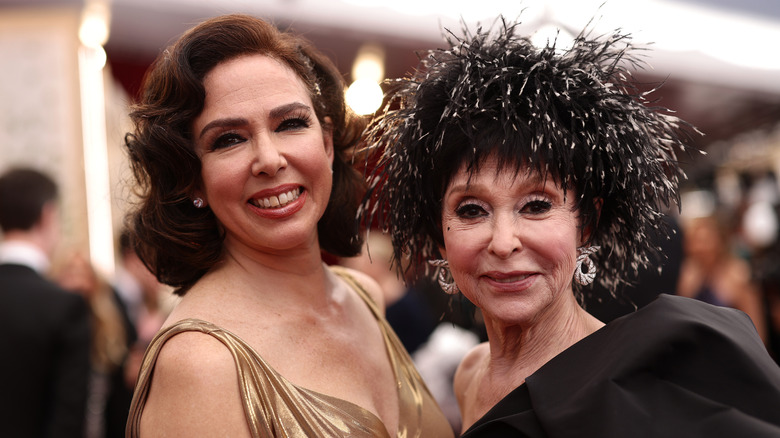 Fernanda Luisa Gordon wearing a gold dress pictured with Rita Moreno in a black feathered hat