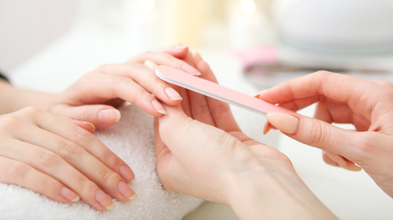 woman getting nails filed