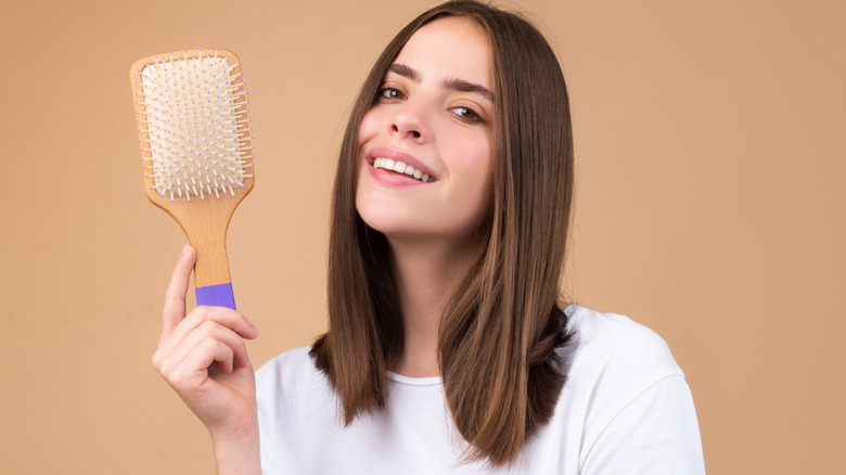 smiling woman holding hairbrush