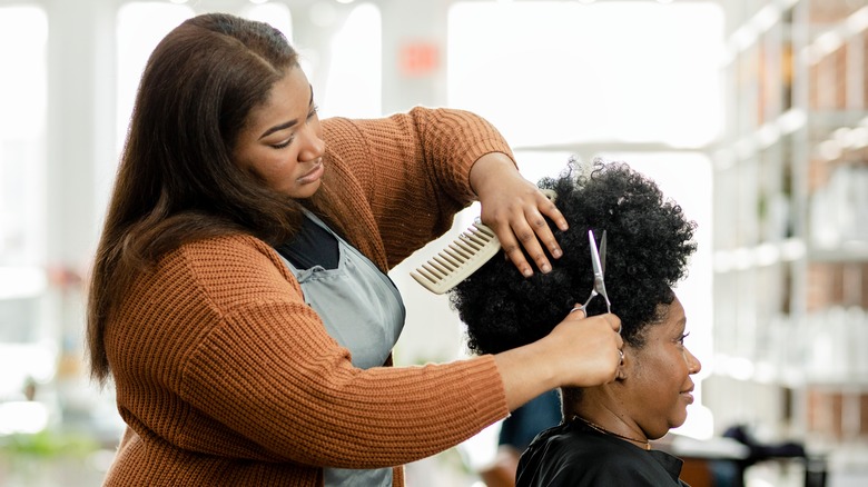 Hairstylist cutting client's hair