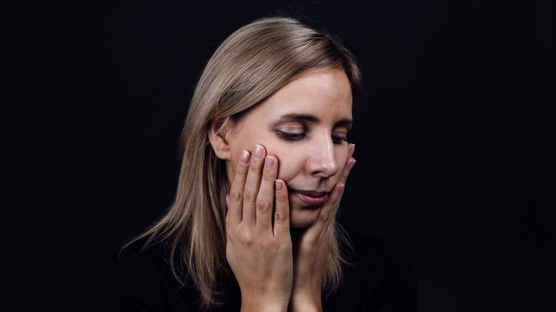 woman holding her face