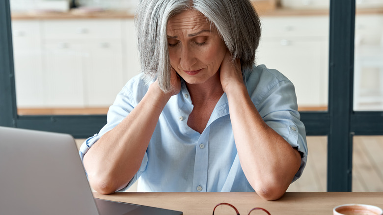 Woman stressed out and holding her neck