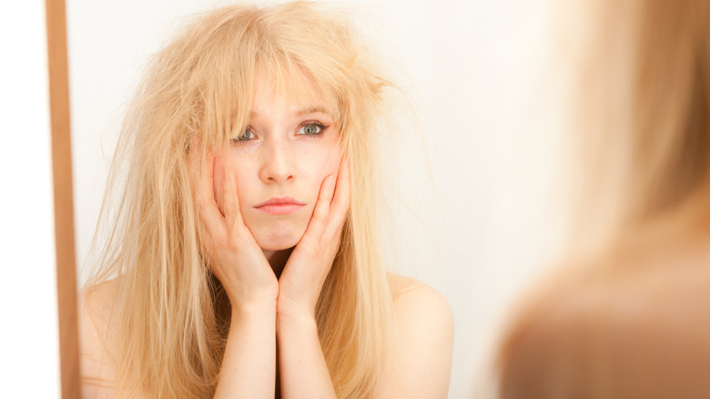 A woman frowning at dry hair